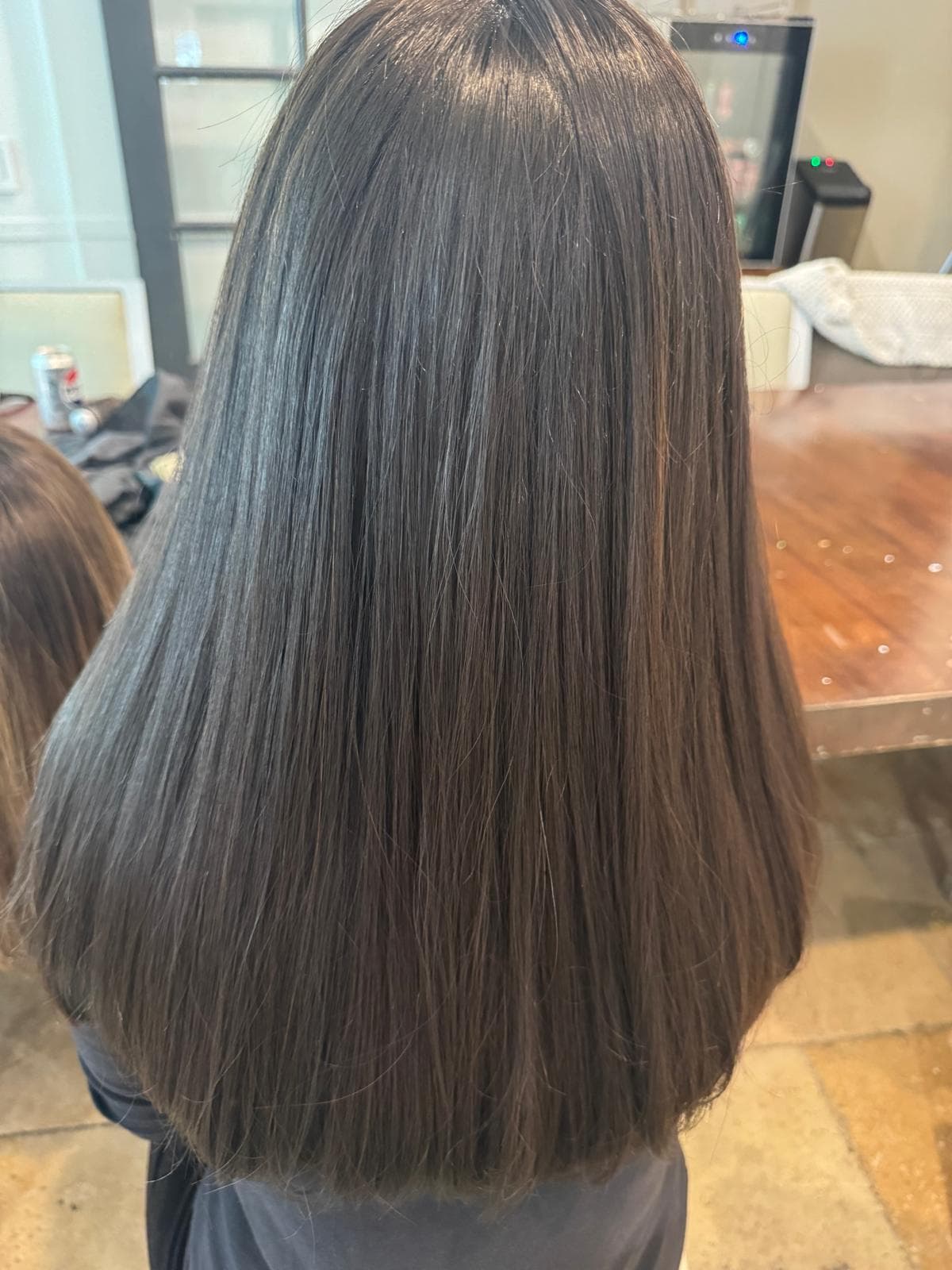 Back view of long, straight, dark brown hair with a smooth, glossy finish.